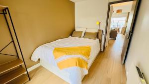 a bedroom with a large bed in a room at Le Panorama, confortable appartement - accès direct à la plage in Bernières-sur-Mer