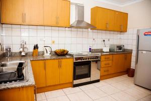 a kitchen with wooden cabinets and stainless steel appliances at Calm Suites Kampala in Kampala