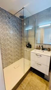 a bathroom with a shower and a sink at Le Panorama, confortable appartement - accès direct à la plage in Bernières-sur-Mer