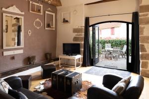 een woonkamer met een grote deur die toegang geeft tot een patio bij Maison 4 in Souvigny