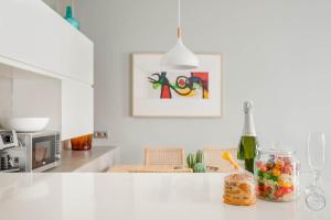 Una cocina con una encimera blanca con un tarro de dulces. en Bo&Co Apartments, en Sitges