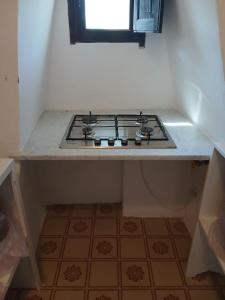 a stove top oven in a kitchen with a window at Casa Moser in Stromboli
