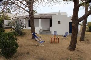 two chairs and a table in front of a house at Casa Moser in Stromboli
