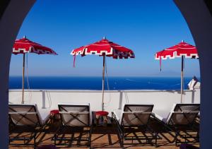 卡普里Il Capri Hotel的海滩上的一组椅子和遮阳伞