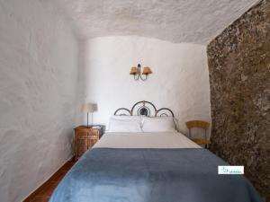 a bedroom with a bed in a white room at Living Artenara - CAVE HOUSE & TERRACE Adults Only in Artenara