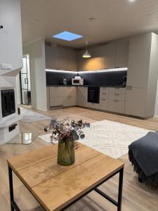 un soggiorno con un vaso di fiori su un tavolo di Apartment Kaarto a Seinäjoki
