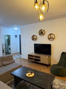 a living room with a tv and a table at A place that will make you feel at your home! in Gjilan