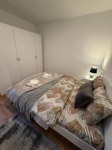 a bed in a bedroom with a white wall at A place that will make you feel at your home! in Gjilan