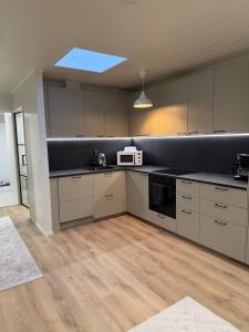 una cucina con armadi bianchi e forno a microonde bianco di Apartment Kaarto a Seinäjoki