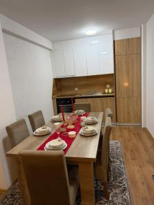 Un comedor con mesa y sillas de madera. en A place that will make you feel at your home!, en Gnjilane