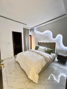 阿比让OLORI HOME - residence Haut standing的卧室里有一张大床，墙上装有灯。 更多8张照片