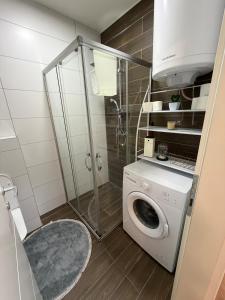 y baño con lavadora y ducha. en A place that will make you feel at your home!, en Gnjilane 6 fotos más