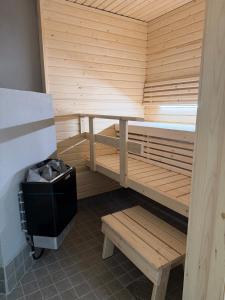 a wooden sauna with a bench and a table at Apartment Kaarto in Seinäjoki +6 photos