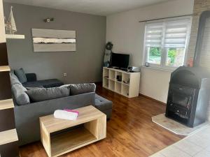 a living room with a couch and a stove at Olive Garden Krk in Brzac