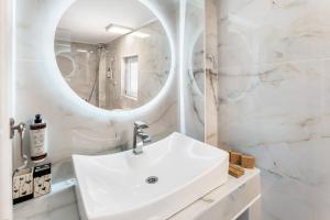 a white bathroom with a sink and a mirror at Doliva Studio John private jacuzzi in Agios Gordios +24 photos