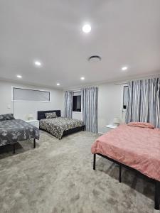 ein Hotelzimmer mit 2 Betten und Vorhängen in der Unterkunft Flat Bush Private Ensuite in Auckland