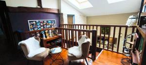 una camera con 2 sedie bianche e un balcone di Gite de Marthon, 10 personnes a Marthon