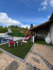 un cortile con sedie, una piscina e una casa di Gite de Marthon, 10 personnes a Marthon