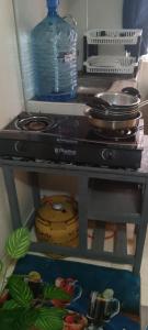 a shelf with a stove and a bottle of water at Utawala studio apartment in Nairobi