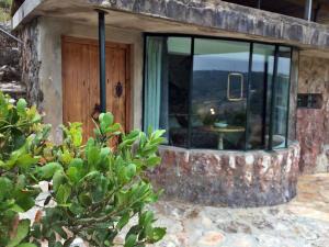 a stone house with a glass door with a table in it at 1/4 na Serra in Rio Maior