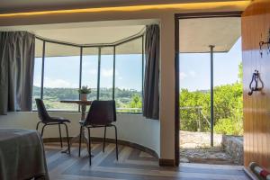 a room with a table and chairs and windows at 1/4 na Serra in Rio Maior