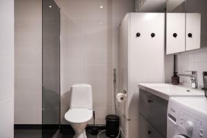 a white bathroom with a toilet and a sink at Cozy and peaceful holiday apartment in Levi in Levi +12 photos