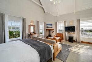 a bedroom with a large bed and a living room at The Farmhouse Hotel in Langebaan