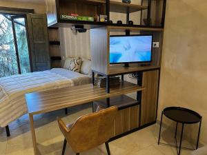 Un dormitorio con una cama y un escritorio con televisión. en Loft Loreto en Val'Quirico, en Santeagueda