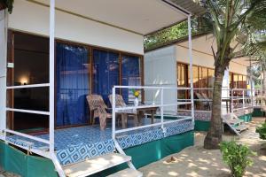 a house with a porch with chairs and a table at Mountain Palm patnem beach in Patnem