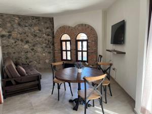 Una sala de estar con una mesa y sillas de madera. en Loft River, en Santeagueda