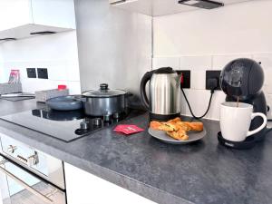 Eine Küchentheke mit einem Teller Essen und einer Kaffeekanne in der Unterkunft Modern 2-Bed Flat in York City Centre - Steps from Christmas Market in York + 9 Fotos