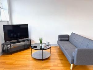 ein Wohnzimmer mit Sofa und Tisch in der Unterkunft York City Centre 2 Bed Flat with Views - Steps from Christmas Market in York + 9 Fotos