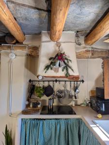 a kitchen with a stove and a shelf with pots and pans at El Carpintero in Trevélez