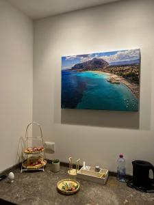 a painting of a beach hanging on a wall at Flower rooms Palermo in Palermo