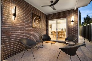 un patio con sedie e un muro di mattoni di Urban Haven Central Wagga a Wagga Wagga
