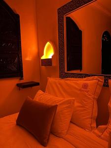 a bedroom with an orange room with a bed with pillows at Ryad Lalla khadija in Marrakech