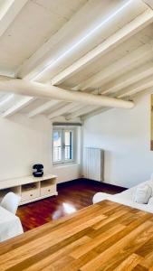 Großes Zimmer mit 2 Betten und einem Holztisch. in der Unterkunft Casa MiA in Salò