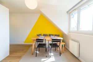 un comedor con una pared amarilla y blanca en BiNiC ' ATTiC - Vue Mer - Centre Binic - Renove, en Binic