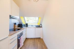 Una cocina con gabinetes blancos y una ventana. en BiNiC ' ATTiC - Vue Mer - Centre Binic - Renove, en Binic