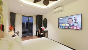 ein Hotelzimmer mit einem TV an der Wand in der Unterkunft Royal Hotel - Trinh Van Bo, Nam Tu Liem in Văn Trì