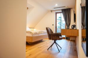 a bedroom with a bed and a desk and a chair at Vineyard Escape Herbersteinova klet in Juršinci