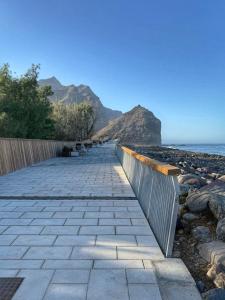 una passerella accanto a una spiaggia con recinzione di My parents' house a Las Marciegas