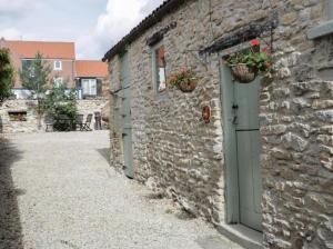 a stone building with a door and flower baskets on it at Platform 17 in Pickering