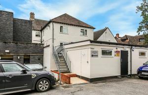 a car parked in front of a white house at The OXTED high street studio in Oxted