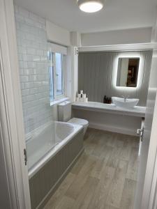 a bathroom with a tub and a toilet and a sink at The OXTED high street studio in Oxted +16 photos