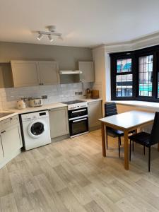 The OXTED high street studio في Titsey: مطبخ مع طاولة وغرفة طعام