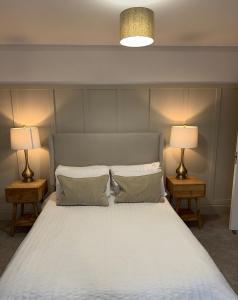 The OXTED high street studio في Titsey: غرفة نوم بسرير كبير مع مصباحين