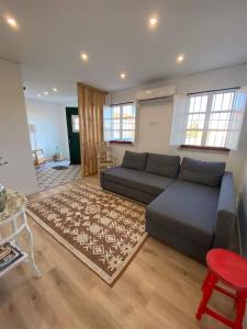 een woonkamer met een bank en een tapijt bij Quinta Nova da Machoca in Évora