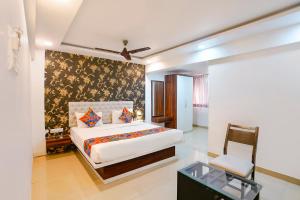 a bedroom with a bed and a chair in it at FabHotel Arsh Executive Inn in Mumbai