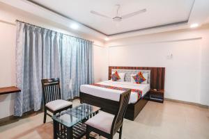 a bedroom with a bed and a table and chairs at FabHotel Arsh Executive Inn in Mumbai